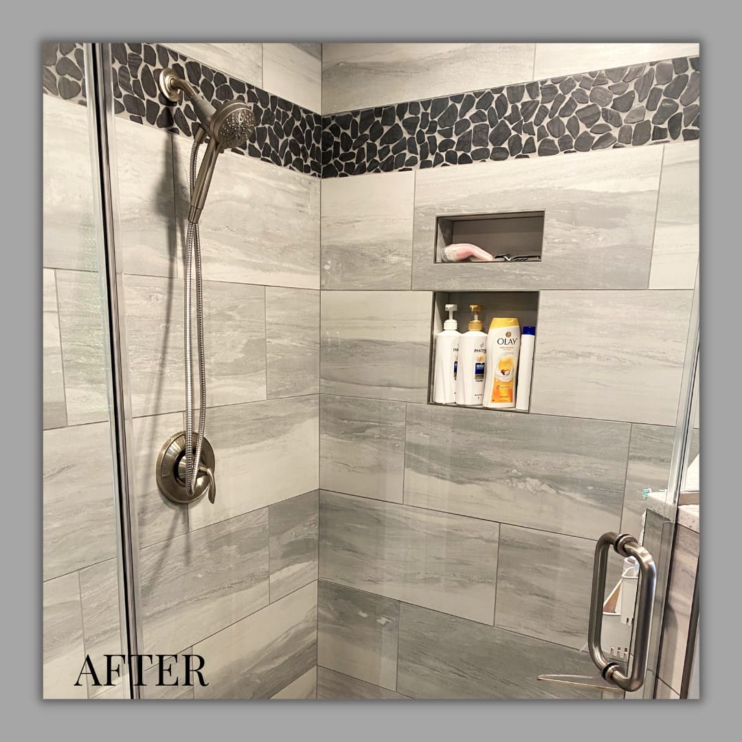 Tile shower with grey wood-look walls, black pebble mosaic accent band, recessed niche, brushed-nickel handheld shower, Edinboro