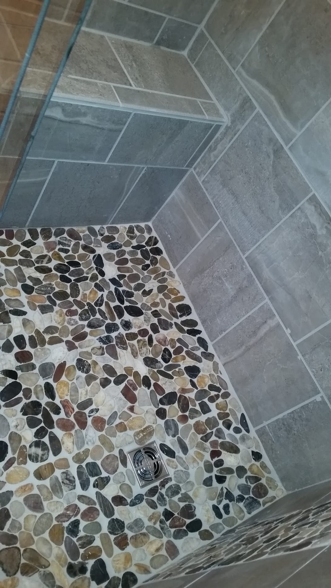 Tile shower with grey slate-look walls and a multicolor river-pebble mosaic shower floor, Edinboro