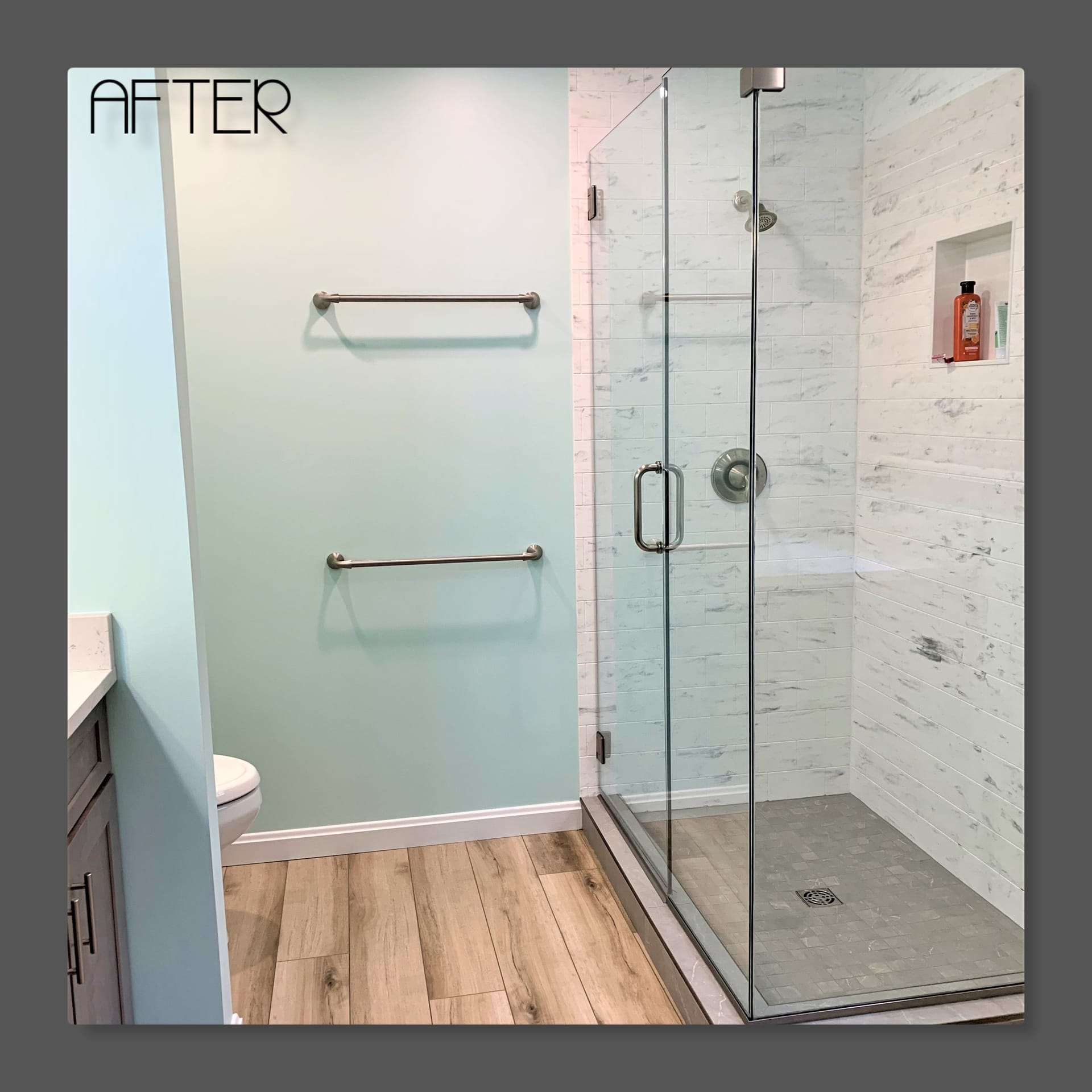 Bathroom with glass walk-in tile shower, white marble-look tile, recessed niche, and wood-look plank flooring, Edinboro