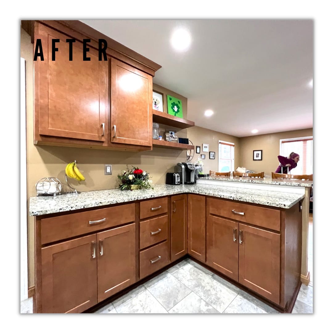 Warm wood shaker kitchen with speckled granite counters, floating shelf, corner peninsula, and tile flooring
