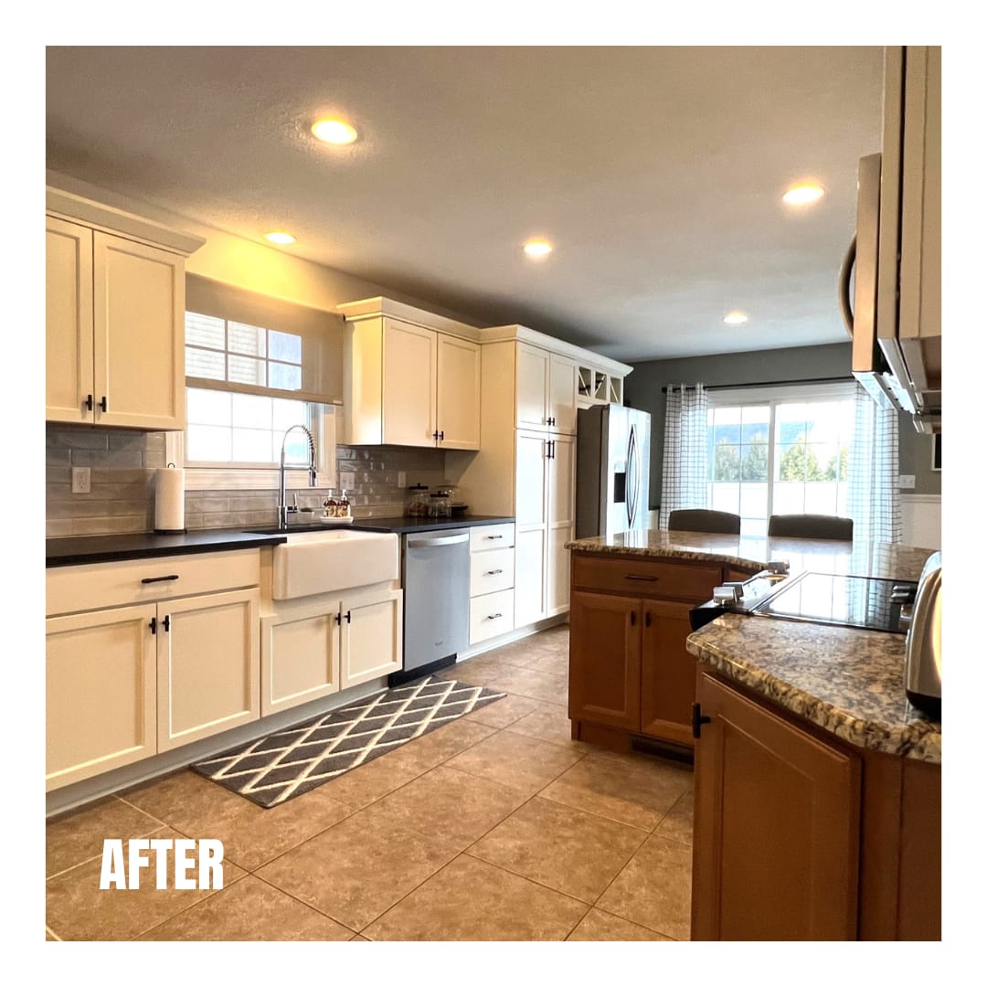 Cream kitchen with grey subway tile backsplash, farmhouse sink, granite-topped island, and tile flooring, Erie County