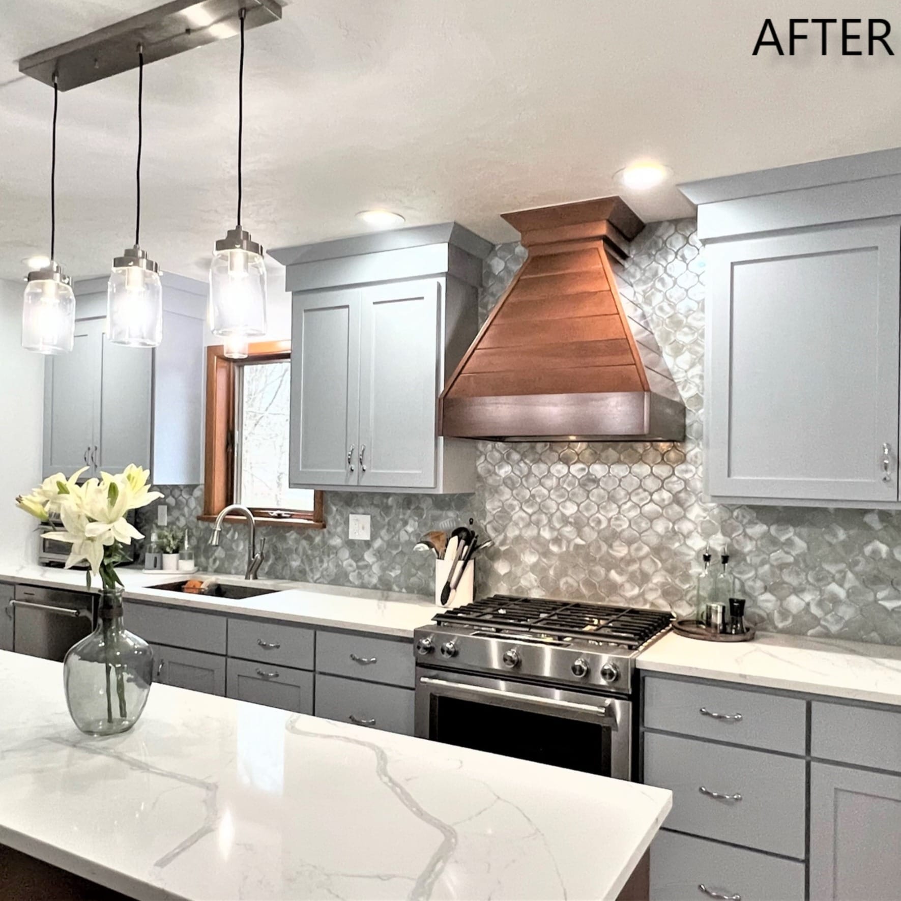 Grey shaker kitchen with copper range hood, silver mosaic backsplash, marble-look quartz counters, and gas range, Erie County