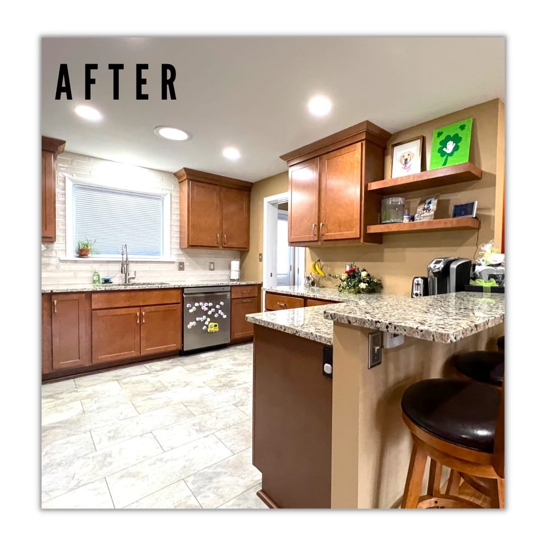 Cherry-toned shaker kitchen with white subway tile, speckled granite peninsula, floating shelves, and tile flooring