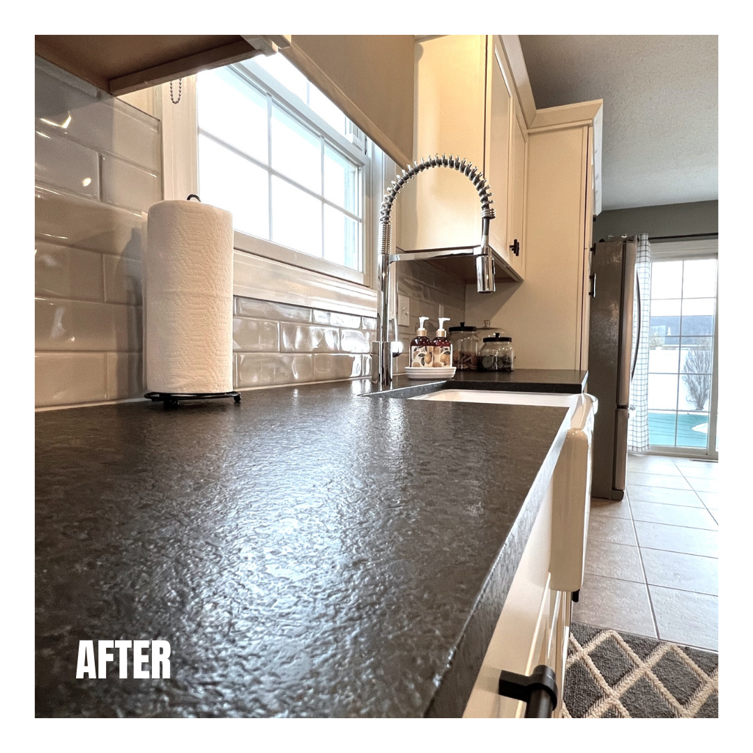 Textured black stone counters with cream cabinets, glossy white subway tile backsplash, coil-spring faucet, and tan tile flooring
