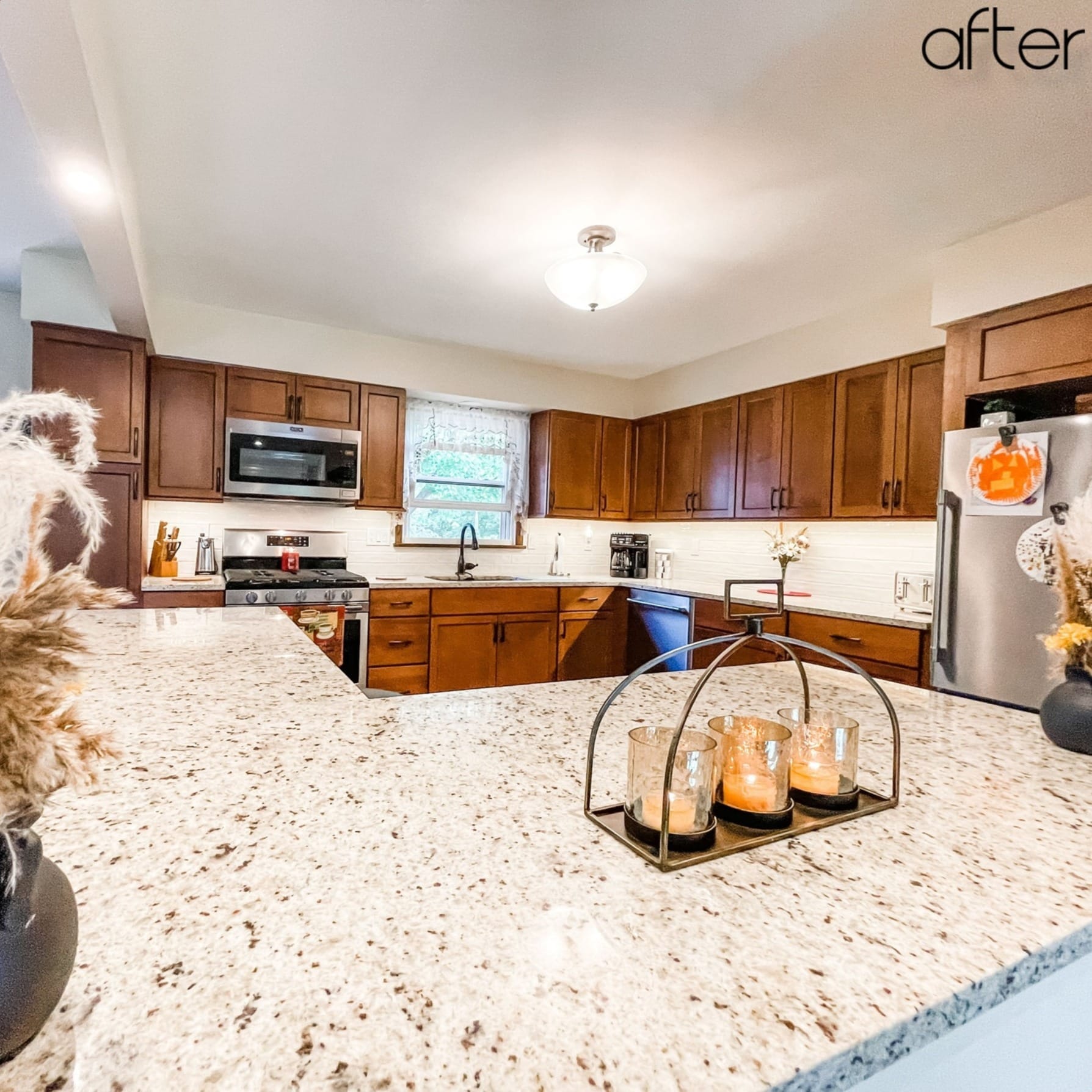 Cherry-toned shaker kitchen with white subway tile, speckled granite peninsula, and stainless appliances, Erie County