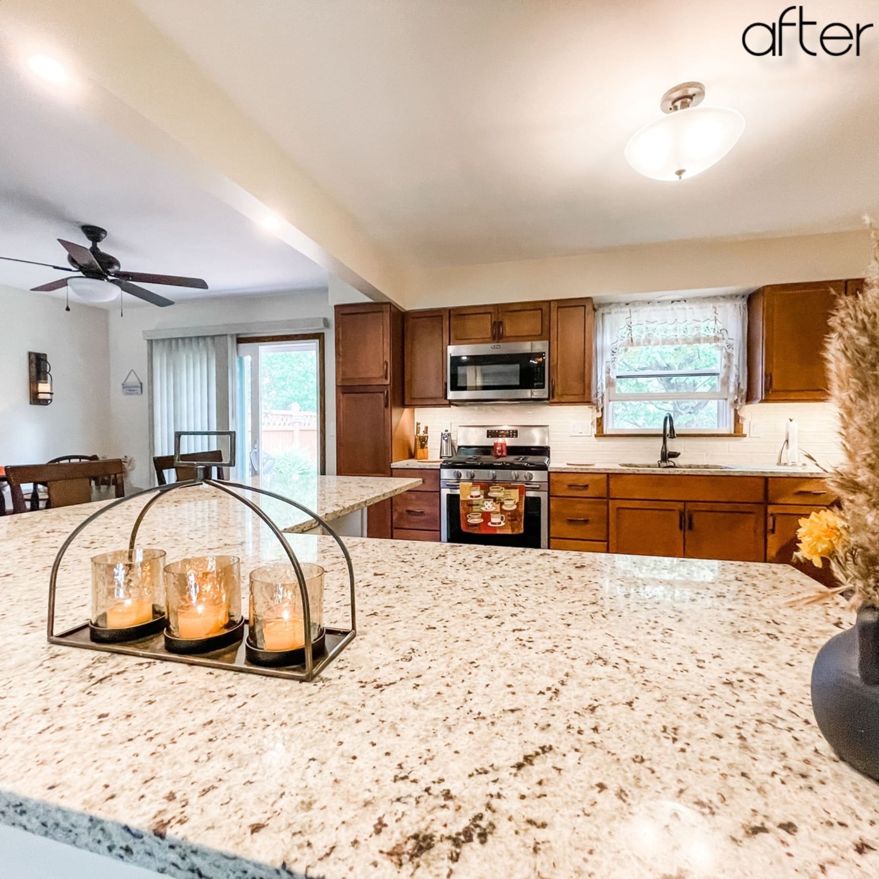Cherry-toned shaker kitchen with white subway tile, speckled granite island, stainless appliances, and open dining area, Edinboro