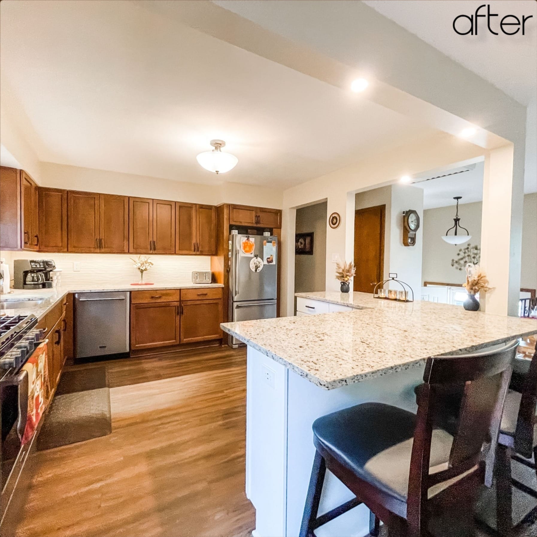 Cherry-toned shaker kitchen with white subway tile, speckled granite peninsula, stainless appliances, and wood-look plank flooring